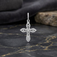 A 10K Gold 3/8 CTW Diamond Cross Pendant rests elegantly on a dark marble surface, its brilliance enhanced by gray and stone backgrounds. This striking two-tone gold cross pendant exudes timeless sophistication, showcasing the allure of every shimmering diamond facet.