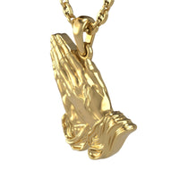 The 14k Gold Praying Hands Pendant is a gold pendant shaped like two hands in prayer, detailed with delicate draped sleeves.