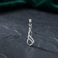 The 1/20 CTW Diamond Infinity Pendant in 10k gold, featuring a twisting infinity design adorned with sparkling diamonds, rests on a dark textured surface with a green velvet background.