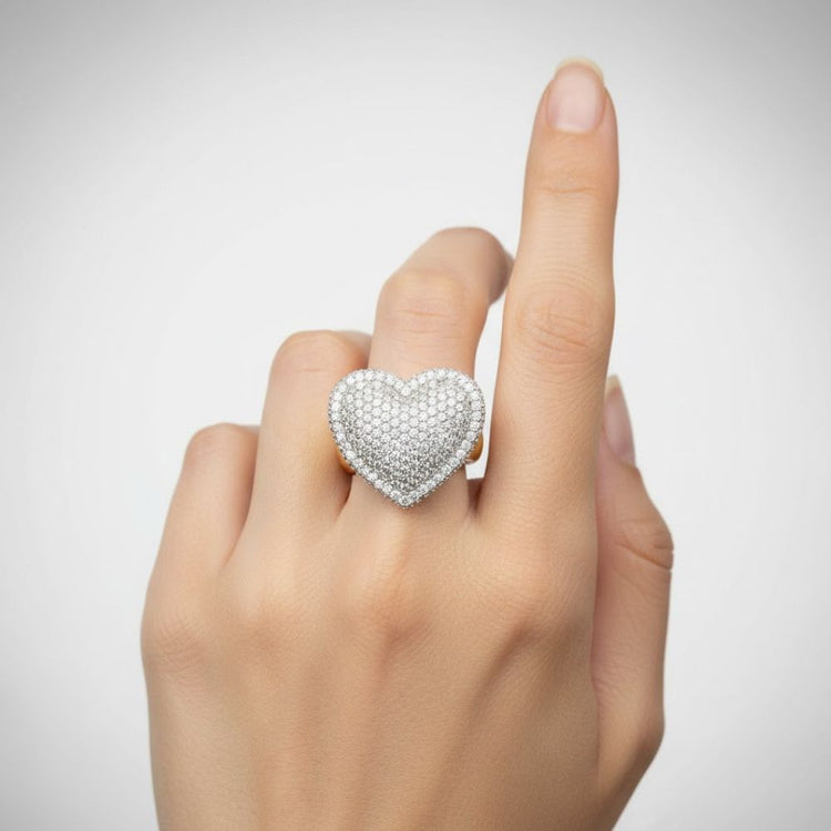 A hand with a light skin tone wears the Iced-Out Heart Cluster Ring 5.46 CT Diamond - 14k Yellow Gold on the middle finger, shown against a plain white background.