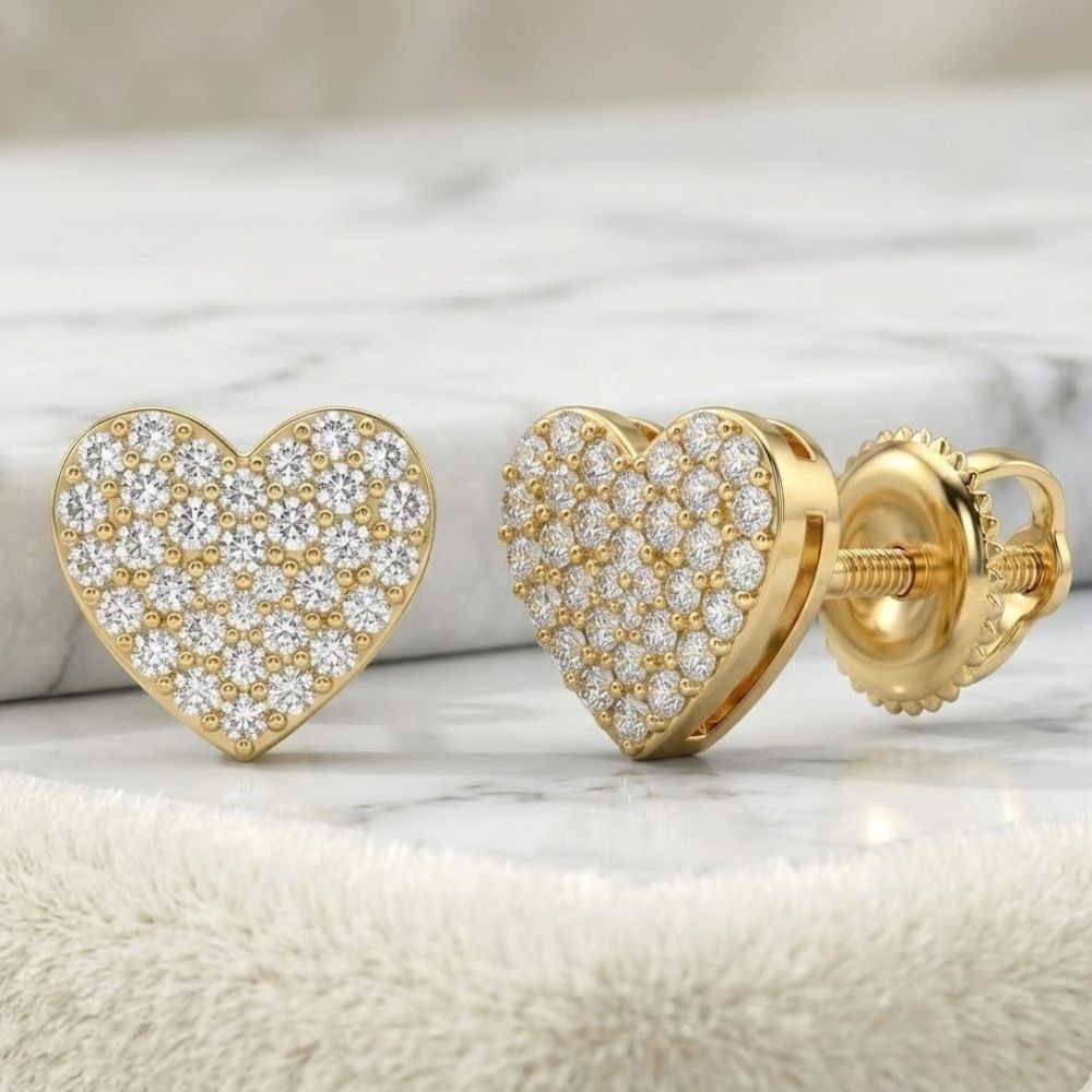 A pair of 1/3CTW Natural Diamond Heart Earrings in sterling silver, encrusted with sparkling white stones, are displayed on a marbled surface—one upright and the other showing the screw-back fastening.