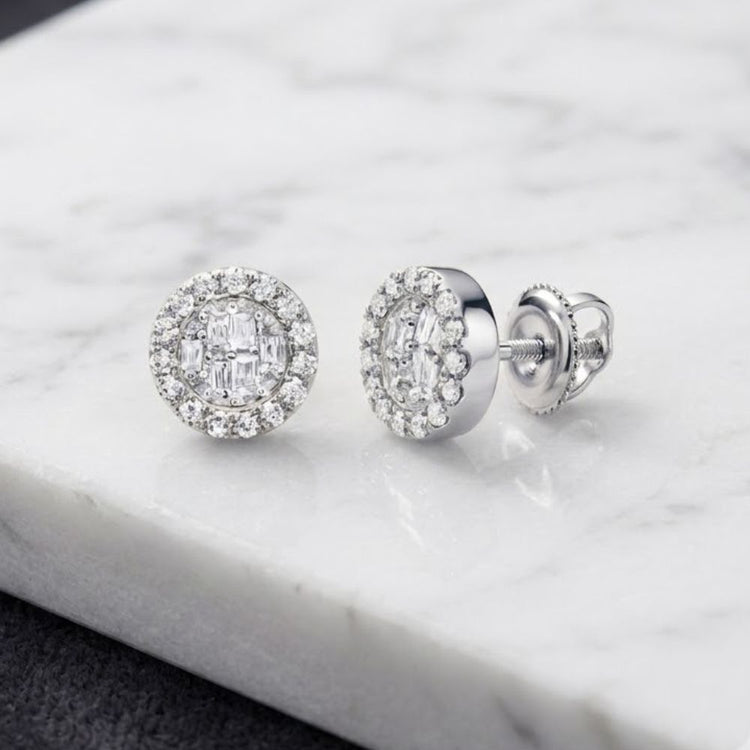 A pair of 1/5CTW Diamond Earrings in 10K gold, featuring round and baguette diamonds in a halo setting, displayed on a white marble surface.