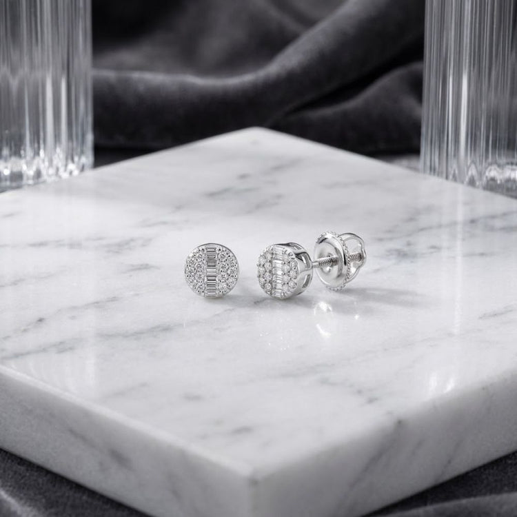 10k Gold Round Diamond Stud Earrings 1/6 Cttw, featuring intricate diamond detailing and set in 10k gold, are displayed on a white marble slab with clear glass and dark velvet in the background.