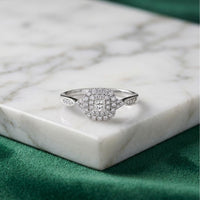 A 1/4 CTW Diamond Double Halo Engagement Ring is displayed on a white marble slab against a green fabric background.
