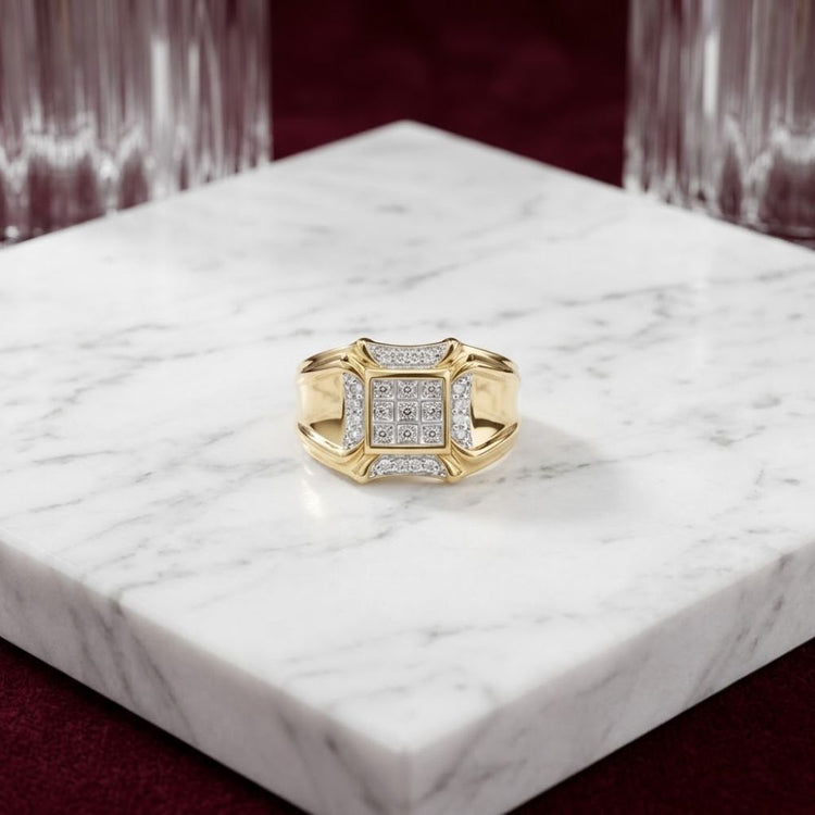 A 10K Yellow Gold Diamond Cluster Ring 1/4CT is displayed on a white marble slab, with crystal glasses and a burgundy background behind it.