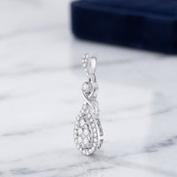 The 10K White Gold 1/2 CTW Diamond Cluster Pendant, teardrop-shaped and elegant, sits upright on white marble with a dark blue box softly blurred in the background.
