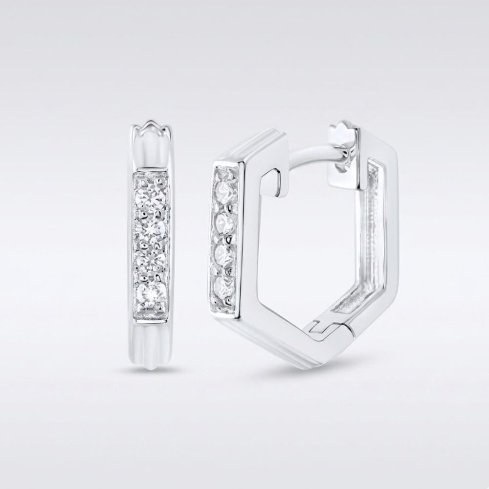 A pair of 10k Gold Diamond Fashion Hoop Earrings (1/8CTW), hexagonal in shape, displayed on a plain background. One earring faces forward, showing a row of sparkling diamonds; the other is open to reveal the clasp.