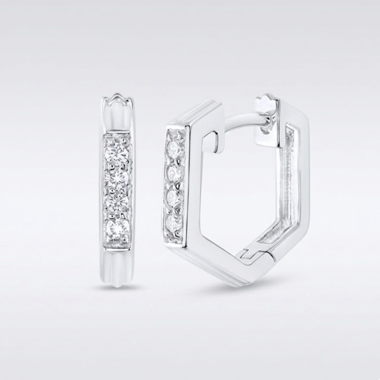 A pair of 10k Gold Diamond Fashion Hoop Earrings (1/8CTW), hexagonal in shape, displayed on a plain background. One earring faces forward, showing a row of sparkling diamonds; the other is open to reveal the clasp.