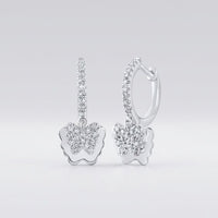 The 10k Gold Diamond Butterfly Hoop Earrings 1/4 Cttw feature butterfly-shaped pendants and hoops, both encrusted with sparkling diamonds and set against a smooth, light gray background.