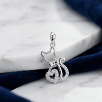The 1/10 CTW Diamond Heart Cat Pendant in 10K Gold, shaped like a cat with a bow and heart-shaped tail and accented with sparkling diamonds, is an elegant gift for cat lovers.