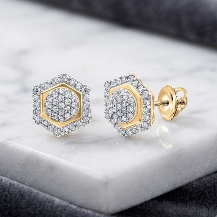 Sterling Silver Diamond Hexagon Cluster Earrings 1/3 Cttw, featuring a stunning hexagonal design set with sparkling diamonds, are showcased elegantly on a white marble surface with a soft gray background.