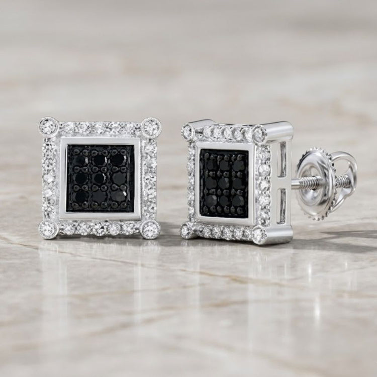 A pair of 10K Gold Black Diamond Square Earrings, totaling 1/4 CTTW, featuring striking black diamonds at the center surrounded by a border of shimmering clear stones and reminiscent of classic diamond jewelry, displayed on a light marble surface.