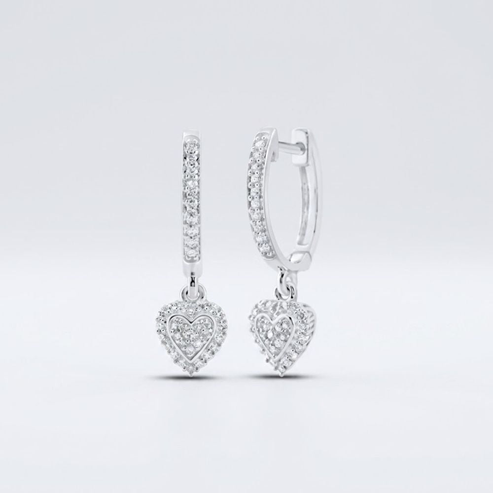 Displayed on a plain light background, the 10k Gold Diamond Heart Hoop Dangle Earrings 1/4 Cttw feature sparkling stones and dangling heart-shaped charms encrusted with diamonds.