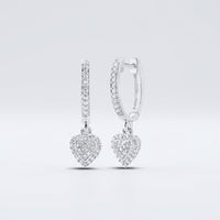 Displayed on a plain light background, the 10k Gold Diamond Heart Hoop Dangle Earrings 1/4 Cttw feature sparkling stones and dangling heart-shaped charms encrusted with diamonds.