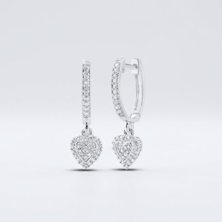 Displayed on a plain light background, the 10k Gold Diamond Heart Hoop Dangle Earrings 1/4 Cttw feature sparkling stones and dangling heart-shaped charms encrusted with diamonds.