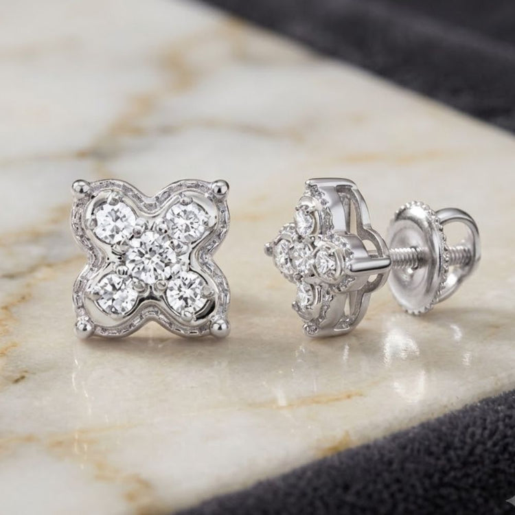 Introducing the 1/6CTW Natural Diamond Clover Earrings in 10K Gold—each earring showcases four brilliant natural diamonds arranged in a graceful clover motif, beautifully displayed on a marble surface. With their floral-inspired design and refined elegance, these earrings add timeless charm to any jewelry collection.