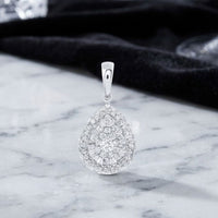 14K Gold 1/2 CTW Diamond Pear Pendant featuring an intricate design in elegant two-tone gold, displayed on a marble surface with a black fabric background.