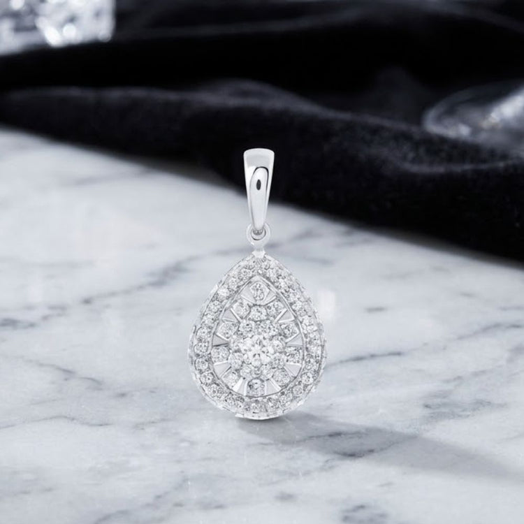 14K Gold 1/2 CTW Diamond Pear Pendant featuring an intricate design in elegant two-tone gold, displayed on a marble surface with a black fabric background.