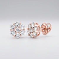 The 10k Gold Diamond Flower Cluster Earrings 1 Cttw feature round, sparkling diamonds in a radiant rose gold setting, displayed on a light gray background.