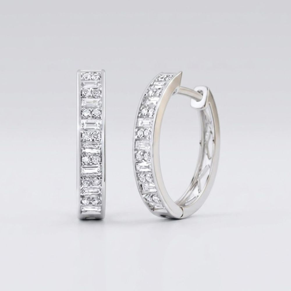 The 1/2CTW Diamond Baguette Hoop Earrings in 14K gold feature a row of sparkling baguette diamonds along the front. Shown: one earring faces forward, the other from the side, against a light gray background.