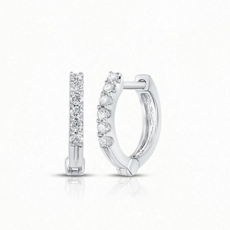 A pair of 10k Gold Round Diamond Hoop Earrings, each featuring a row of sparkling diamonds on the front, is displayed—one shown from the front and one from the side—set against a plain white background.