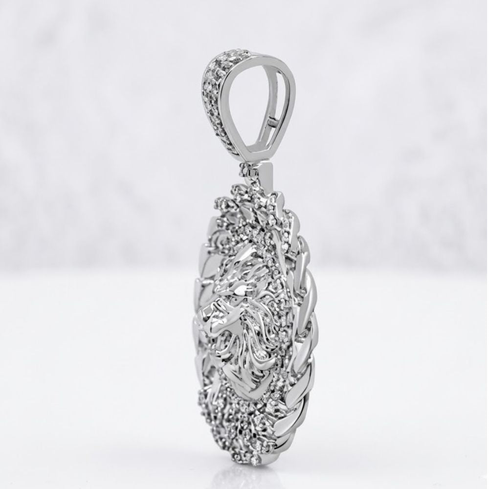 The Diamond Lion Face Cuban Charm 1/2CT Sterling Silver showcases a detailed lion’s head bordered by textured silver, set in an oval design and photographed against a soft, blurred white background.
