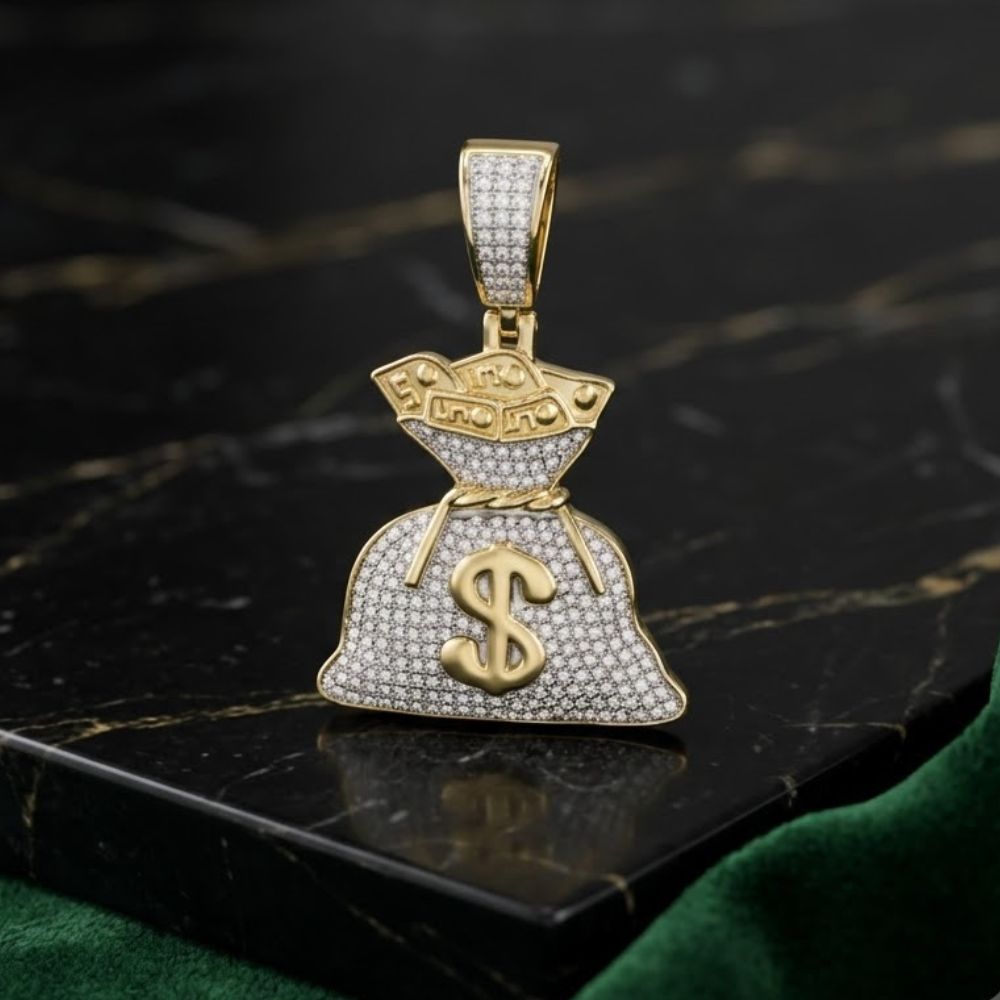 The 10K Gold Diamond Money Bag Pendant 1/2 CTTW, featuring sparkling stones in 10K yellow gold, sits on a dark marble surface with green velvet fabric nearby.