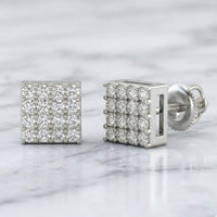 The Sterling Silver Diamond Square Earrings 1/6 Cttw feature grid-like patterns with multiple small diamonds set in square sterling silver, shown on a marble surface.