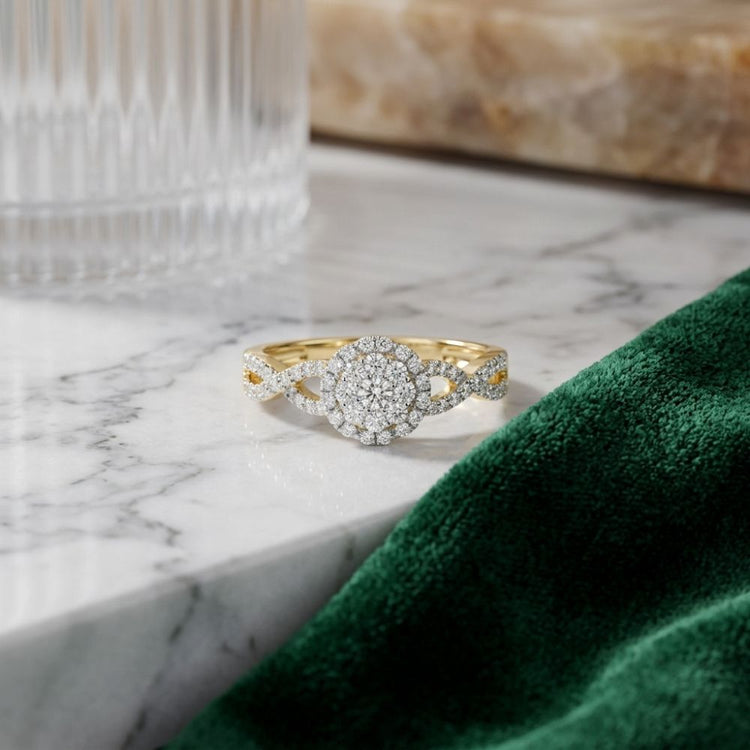 The 1/2 CTW Diamond Flower Bridal Ring – 14K Gold is displayed on a marble surface near a green velvet cloth and a glass container, showcasing its round cluster of small diamonds arranged in a floral design.