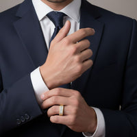 A man in a dark suit adjusts his cuff, showcasing the 10k Gold Round Diamond Band Ring 1/2 Cttw on his other hand. His face is hidden, highlighting the ring's elegance alongside his formal attire.