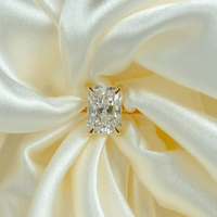 The 3.01ct Radiant Lab Diamond Solitaire Engagement Ring in 14k solid yellow gold is showcased on softly draped ivory satin fabric.
