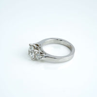 The 3.08CTW Round Trilogy Lab Diamond Engagement Ring in 14K white gold features a large central lab diamond with two smaller side stones on a simple band, shown against a white background.