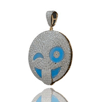 The Happy Face Diamond Pendant - 14k features a winking emoji in yellow gold, accented with natural diamonds and blue enamel, shown on a white background with a subtle reflection below.