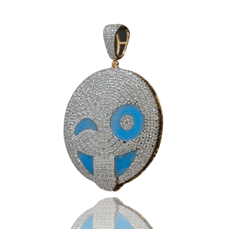 The Happy Face Diamond Pendant - 14k features a winking emoji in yellow gold, accented with natural diamonds and blue enamel, shown on a white background with a subtle reflection below.