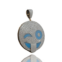 The Happy Face Diamond Pendant - 14k is a round silver piece encrusted with natural diamonds, featuring a winking face with its tongue out and blue accents on the eyes and mouth.