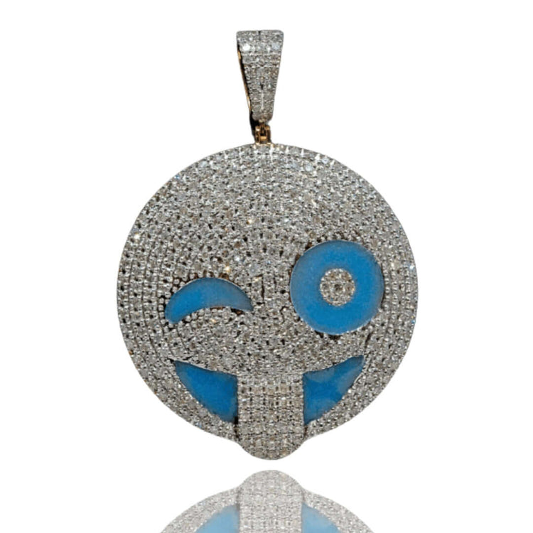 The Happy Face Diamond Pendant - 14k is a round, silver pendant encrusted with natural diamonds, showcasing a playful emoji face with blue eyes and a tongue out on a white background.