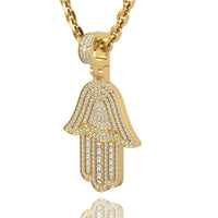 The 14k Gold Hamsa Hand Pendant with Diamonds shines on a thick gold chain, its sparkling diamonds creating a radiant look against a crisp white background.
