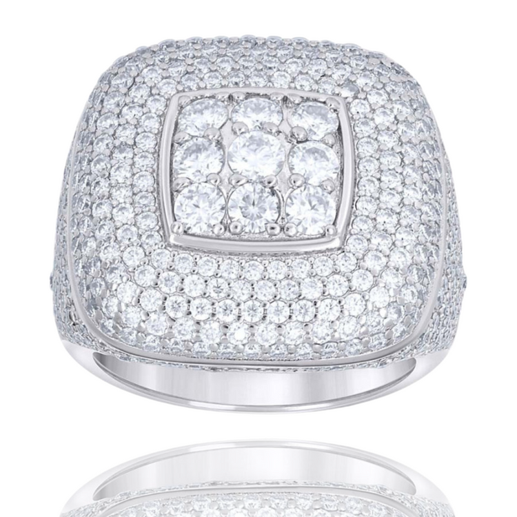 The Silver Moissanite Square Head Ring features a sterling silver band with small round stones and a raised central cluster, displayed elegantly on a white background.