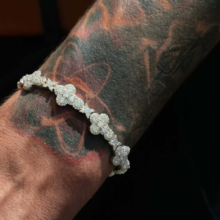 A close-up of a tattooed wrist wearing a sparkling Moissanite Cross Fancy Bracelet in 925 sterling silver, set against a dark background.
