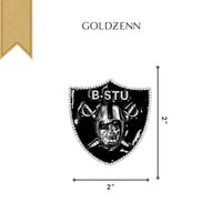 Centered on a white background with GOLDZENN text above, the Raiders Custom Pendant Moissanite – 14K White Gold features a black and silver shield badge with "B STU" and a helmeted figure, measuring 2" x 2", in the style of Custom Raiders Jewelry.