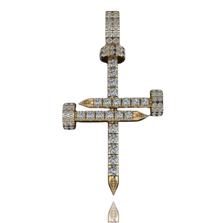 The Diamond Nail Cross Pendant – 14K Gold features two intersecting diamond-encrusted nails forming a cross, displayed on a reflective surface.