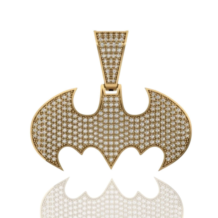 The Diamond Bat Emblem Pendant - 14k features the iconic Batman logo in gold, set with sparkling diamonds, and is shown on a white background with a subtle reflection beneath this bold statement jewelry piece.