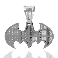 The Diamond Bat Emblem Pendant - 14k is shaped like the Batman logo, with grid-like patterns and small holes on its silver surface. Displayed against a white background with a reflection, it's perfect as statement jewelry.