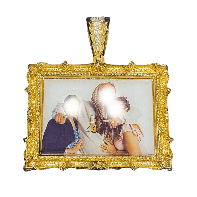 The 14K Gold Diamond Bail Big Frame Picture Pendant features ornate detailing and holds a photo of three people, with two faces obscured by bright glare, adding an elegant touch to the piece.