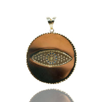 The Eye Pendant – 10k is a round gold pendant with a polished metallic finish, showcasing a central eye design accented with blue, gold, and silver details—an elegant choice for men's jewelry.