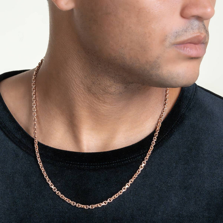 A person in a black shirt wears the 3.5mm Solid Rose Gold Cable Link Chain, seen from the shoulders up with their face partially visible and slightly turned to the side. The background is plain and light-colored.