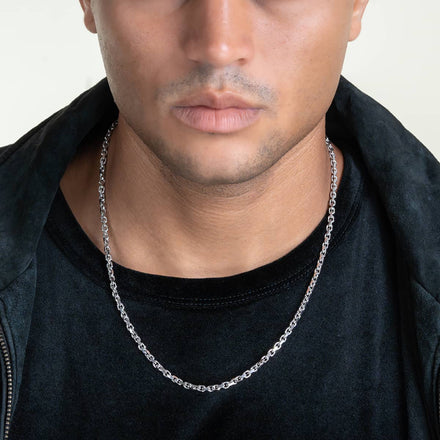 Close-up of a person wearing the 3.5mm Solid White Gold Power-Cable Link Chain, paired with a black shirt and jacket. The person's face is partly visible, emphasizing the chain's elegant design and stylish outfit combination.