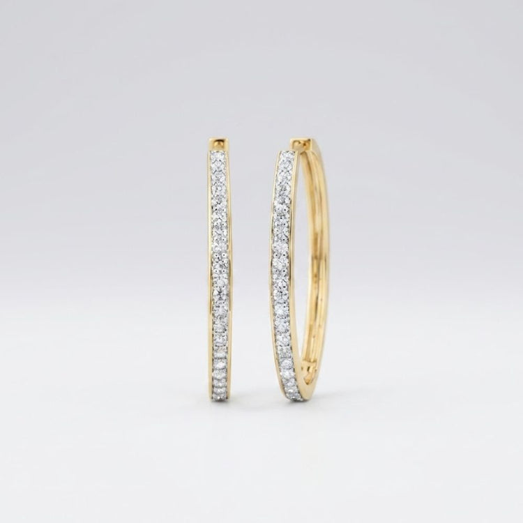 The 14k Yellow Gold Diamond Fashion Hoop Earrings 7/8CTW are shown upright on a plain white background, featuring hoops encrusted with small natural diamonds along the front outer edge.