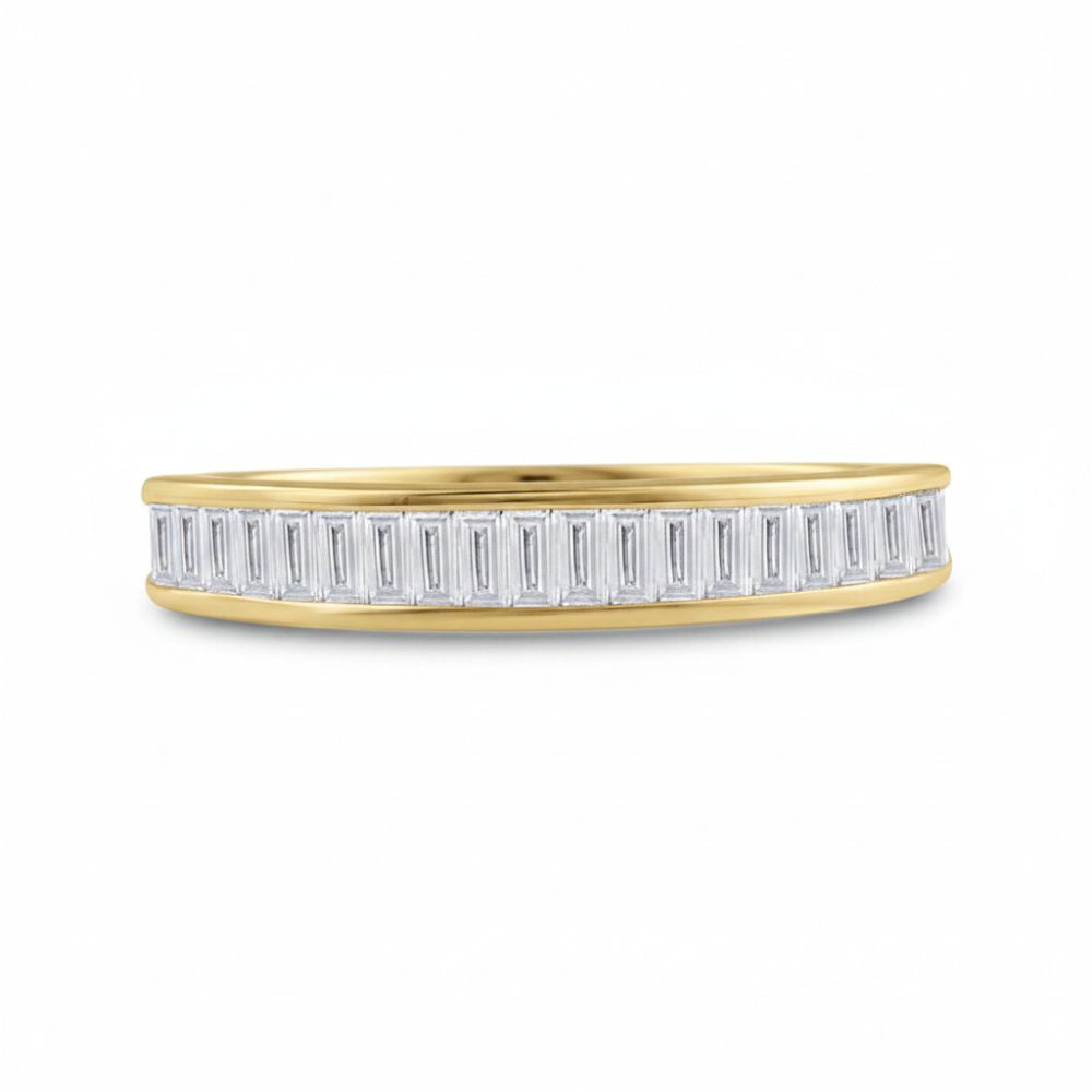 The 10k Yellow Gold Baguette Diamond Wedding Band 1/2 Cttw showcases a row of vertically set rectangular baguette diamonds along the sleek band in a modern design, shown against a plain white background.