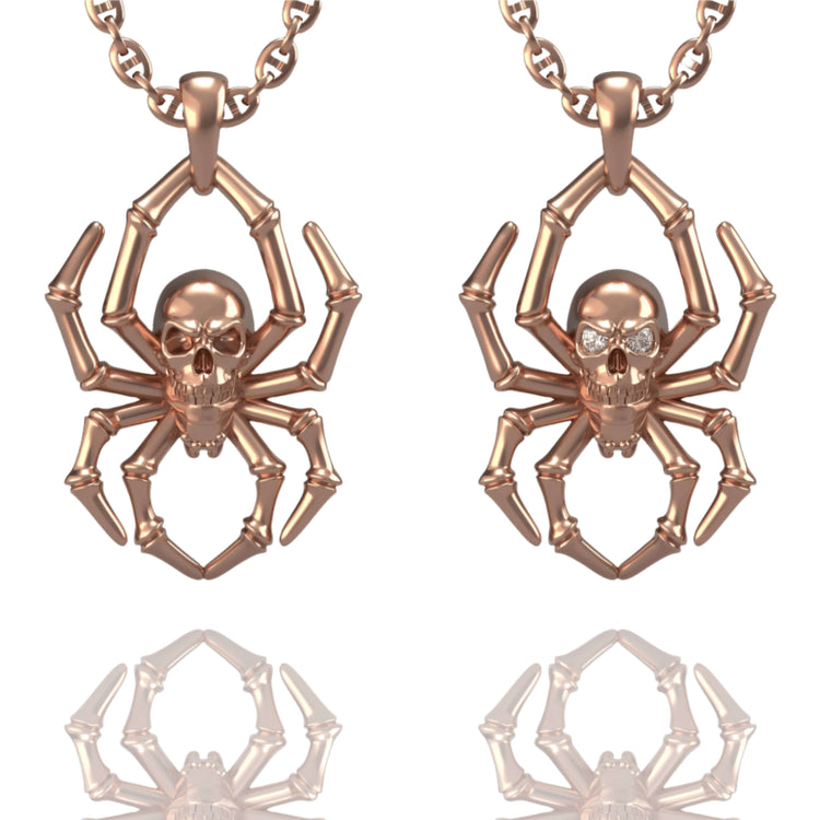 Displayed side by side on a white background are two rose gold 14k Gold Spider Skull Pendants, each featuring a skull at the center of a spider design and hanging from matching chains.